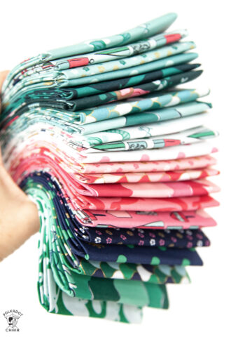 hand holding stack of colorful folded fabrics