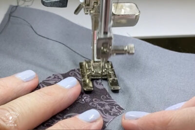 sewing machine foot sewing black and gray fabric