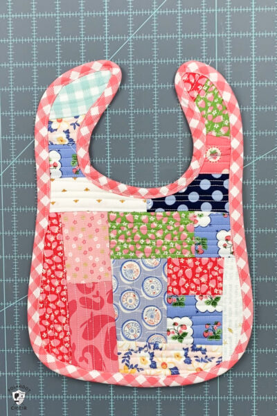 completed and bound baby bib on blue cutting mat