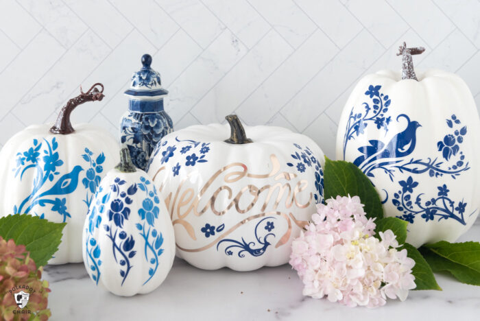 blue and white pumpkins on white table with flowers