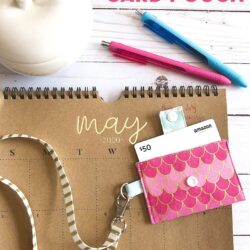 pink keychain card pouch on brown calendar on white tabletop