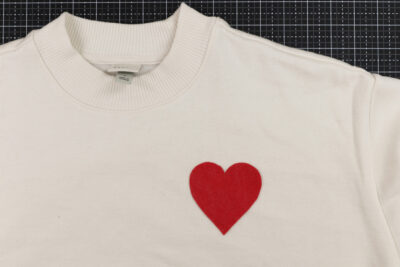red heart on ivory shirt on black cutting mat