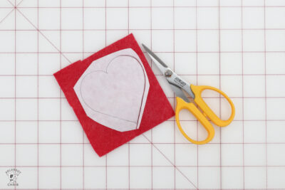 red felt and scissors on white cutting mat