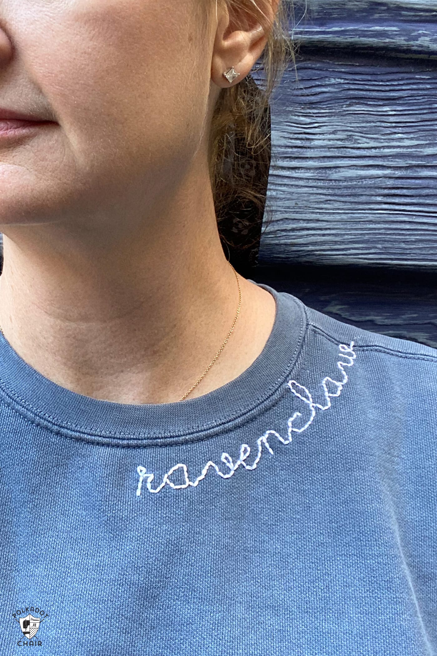 close up of woman wearing navy sweatshirt with ravenclaw embroidered on the collar