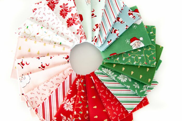 photo of a stack of folded santa claus lane fabric on white background