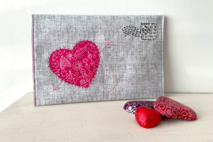 gray fabric envelope on white table with chocolates