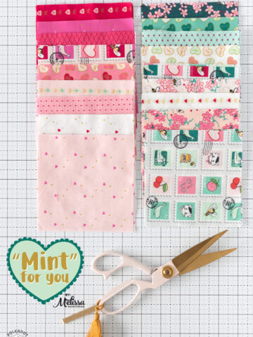 colorful fabric squares on white cutting mat with scissors