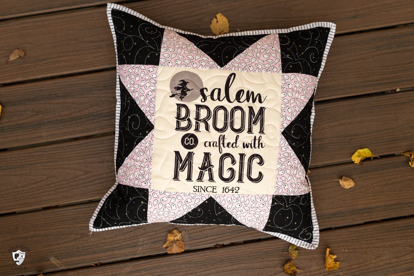 two black and white pillows on deck outdoors with halloween quilt