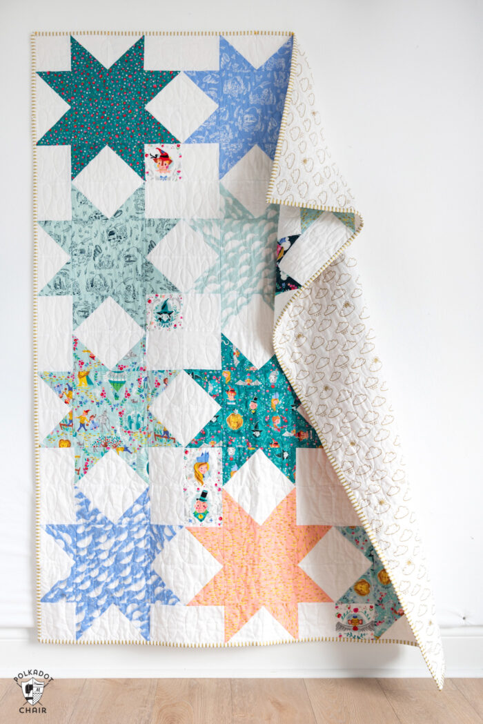 Quilt with folded over top corner hanging on white wall