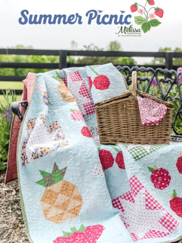 picnic basket and quilt on bench outdoors