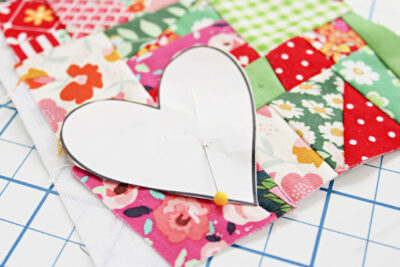 heart pinned to colorful fabric scraps on table