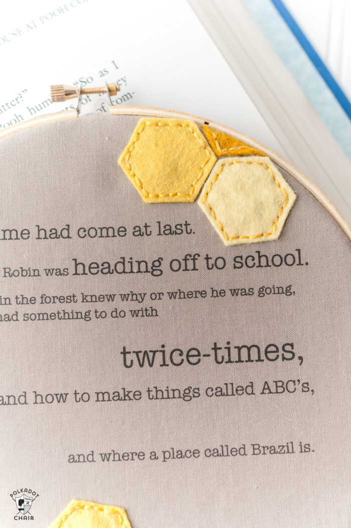 winnie the pooh quote framed in embroidery hoop on book and white table