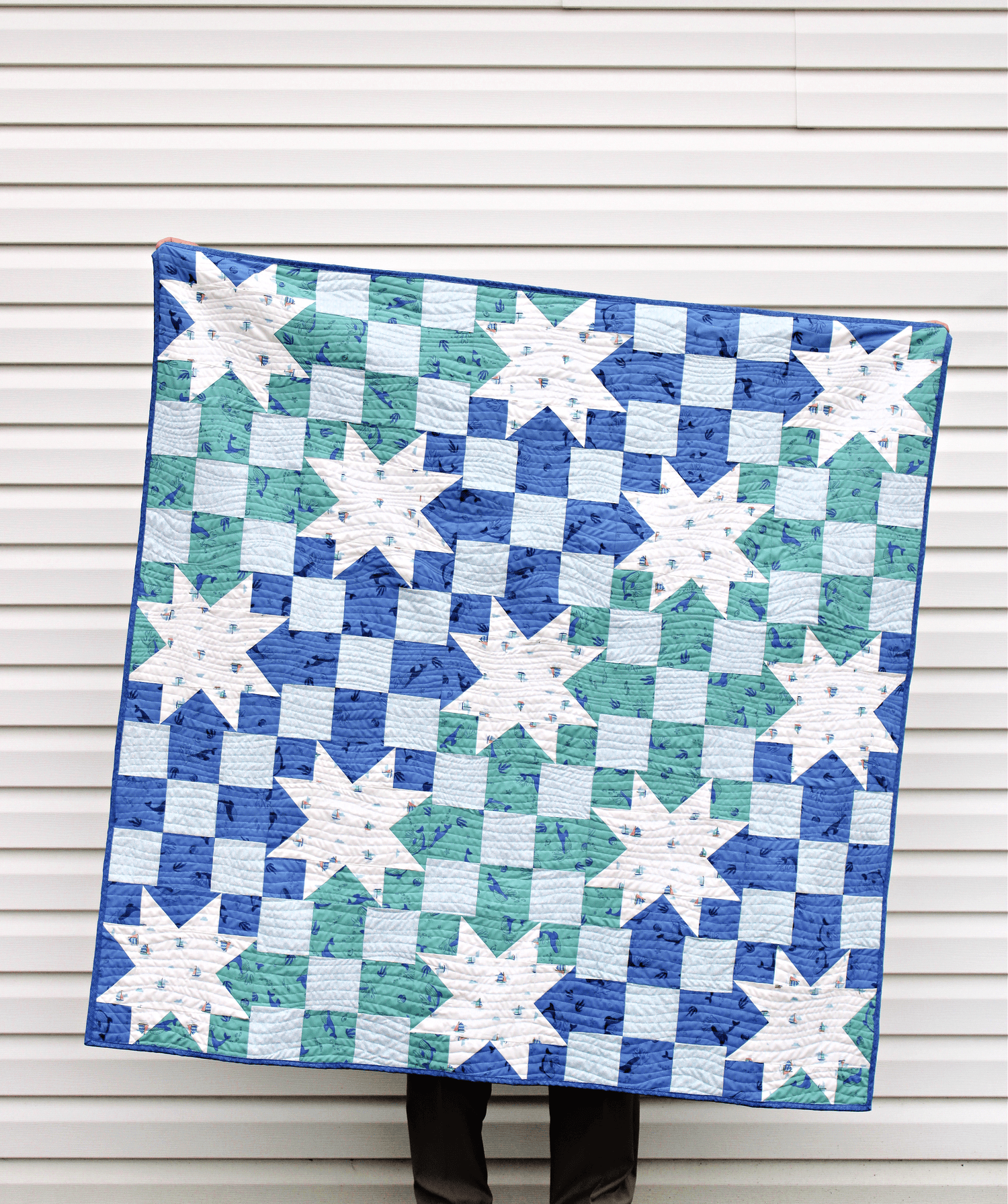 blue and white star quilt in front of white wall